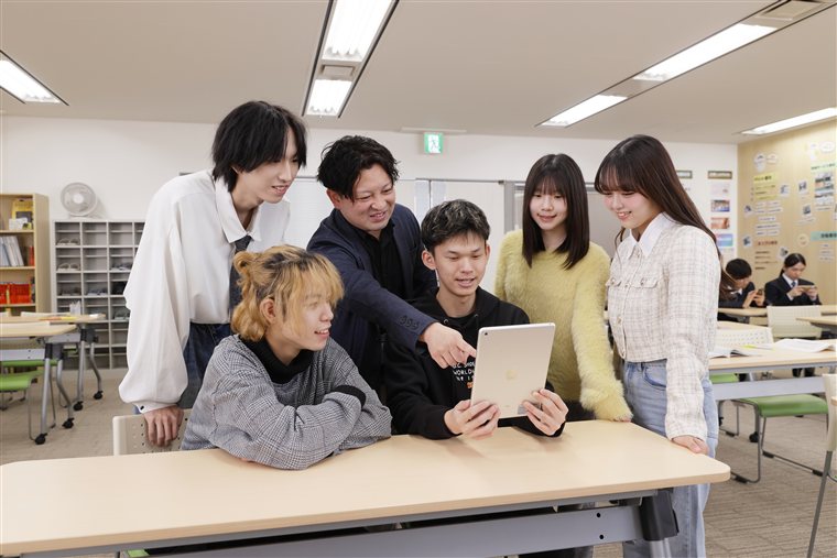 タブレットを見ながら学ぶ生徒とスタッフ
