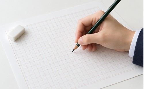 原稿用紙に作文を書く手元